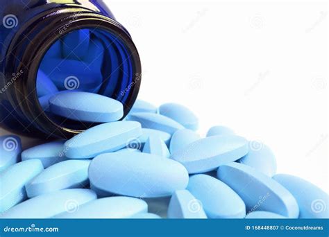 Light Blue Oval Shaped Pills Scattered from Deep Blue Glass Bottle on White Background Stock ...