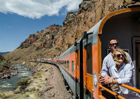 a man and woman standing on the side of a train