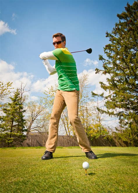 Man in Green and White Stripes Long Sleeve Shirt Holding Black Golf Club · Free Stock Photo