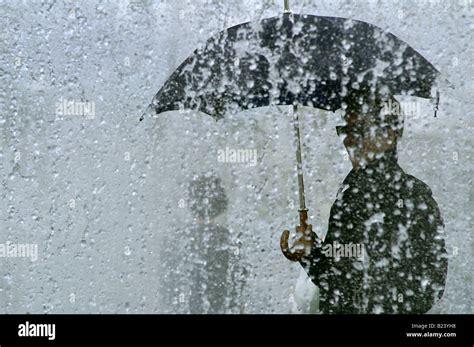 man with umbrella during very heavy downpour, rainstorm in London Stock Photo - Alamy