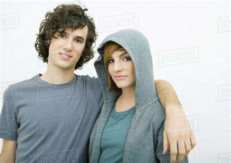 Young couple, man with arm around woman's shoulders, portrait - Stock Photo - Dissolve