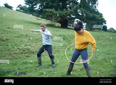 Couple hula hooping in field Stock Photo - Alamy