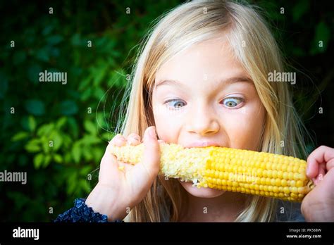 Portrait of girl eating sweet boiled sweet corn outdoor Stock Photo - Alamy