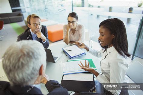 Business people talking at table in office building — women, partners - Stock Photo | #199735546