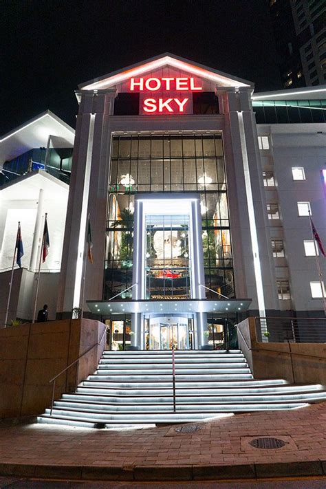 the hotel sky is lit up at night with bright lights on it's entrance