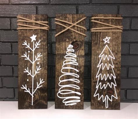 three wooden signs with christmas trees painted on them