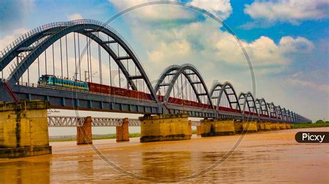 Image of Cargo train passing on a railway bridge across the godavari ...