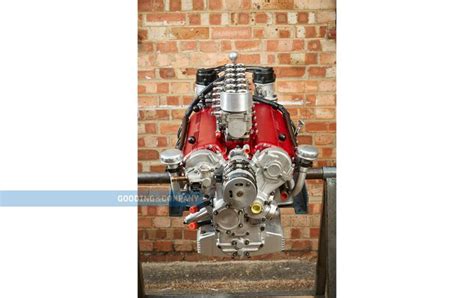 a red engine is sitting in front of a brick wall