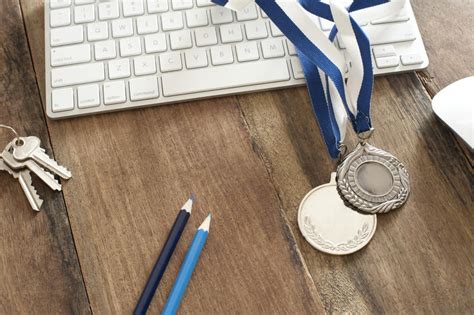 Free Stock Photo 11909 Silver Medals on Rustic Wood Computer Desk | freeimageslive