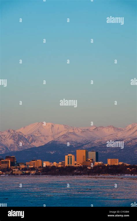 THE CHUGACH MOUNTAINS STAND BEHIND THE ANCHORAGE SKYLINE AT DUSK Stock Photo - Alamy