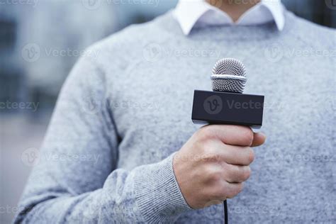 Male hand with a reporter microphone. Journalist during his work ...