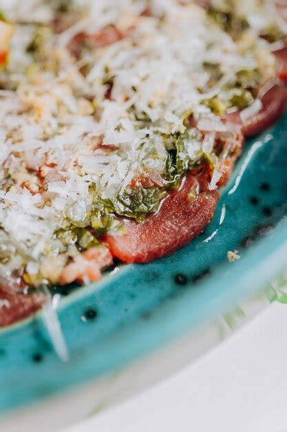 Premium Photo | Beef carpaccio with pesto sauce and parmigiano cheese decorated by salad and ...