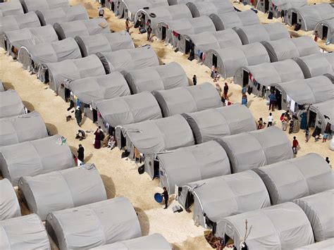 Syrian Kurdish refugees stand outside their tents at a refugee camp near Suruc, Turkey - World ...