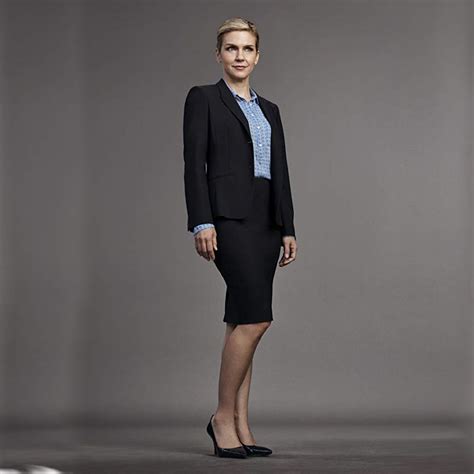 a woman in a business suit posing for the camera with her hands on her hips