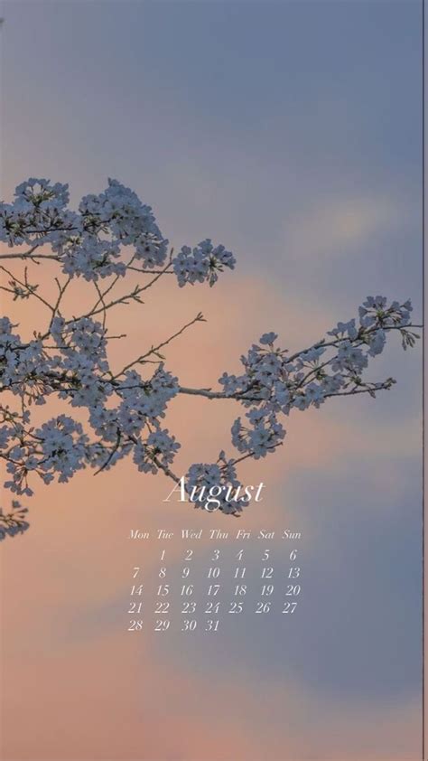 a wall calendar with a tree branch in the foreground and clouds in the ...