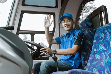 A Male Bus Driver in Blue Uniform Looks at His Watch while Sitting ...