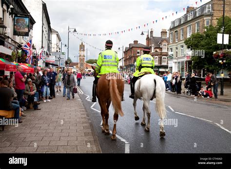 Mounted police on horses patrolling the street, Newmarket town Suffolk ...