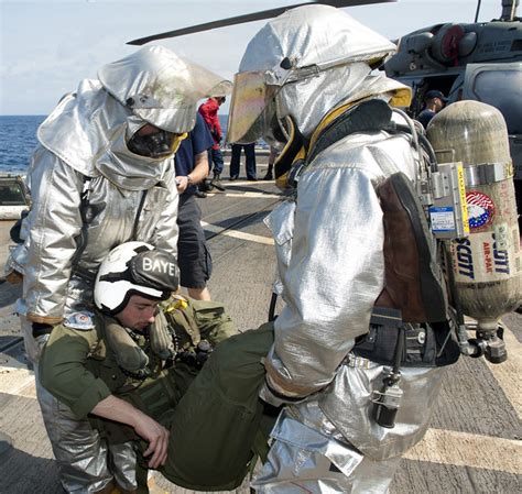 Sailors move a helicopter crash victim during a damage control drill aboard USS Samuel B ...