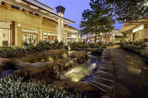 Store fronts light up the exterior walkway at The Shops at La Cantera ...