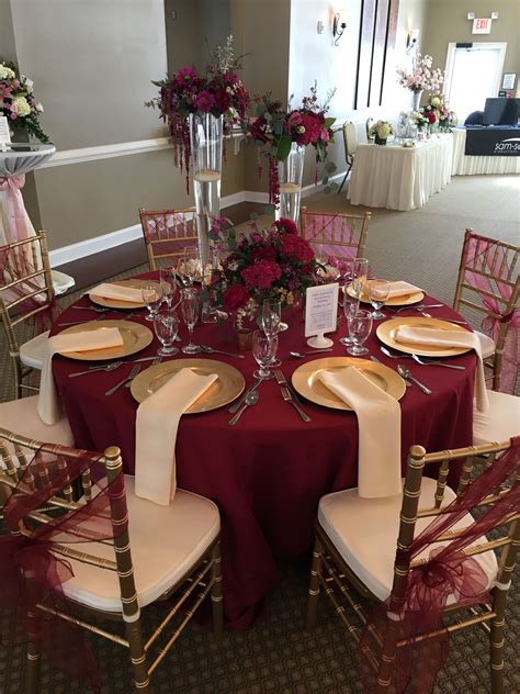 This gorgeous table set up is filled with upgrades! Floor length Burgundy table cloth, champagne ...