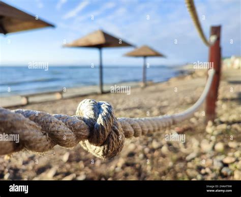 Rope fence with knot on summer beach background Stock Photo - Alamy