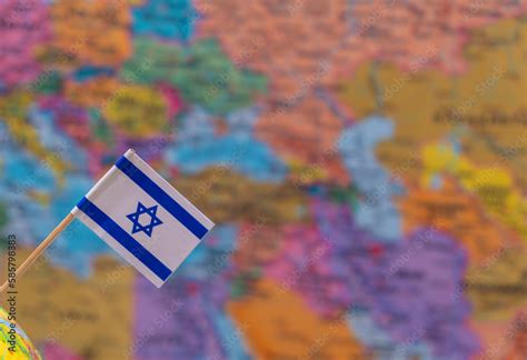 The flag of Israel on the background of a blurry map is out of focus ...