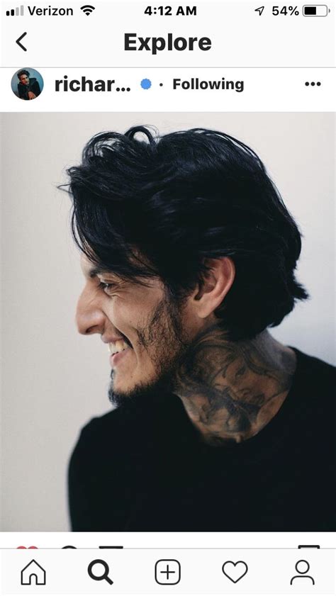 a man with tattoos on his neck smiling