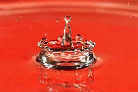 HD wallpaper: Closeup shot of a water drop splash on red background ...