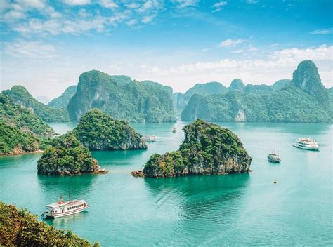 an island with several small boats in the water and mountains on either side are seen