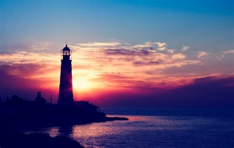 Premium Photo | Lighthouse at the sunset on the beach