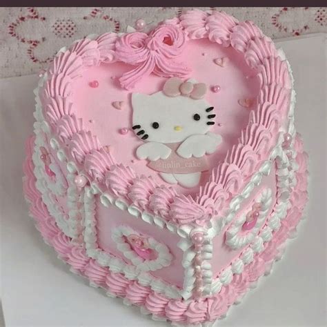 a hello kitty heart shaped cake with pink frosting