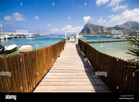 Pier and boats in the beautiful scenery of San Vito lo Capo beach, Trapani Province, Sicily ...