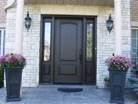 two large planters with flowers in front of a home door and entry way ...