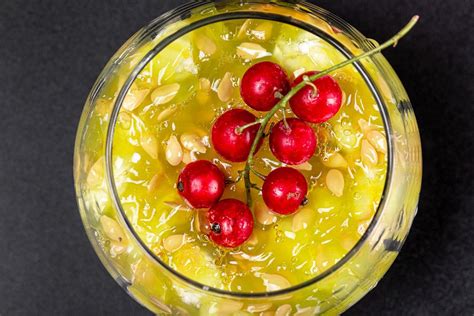 Top view, a sprig of red currant on the pulp of a Kiwano fruit with seeds in a glass - Creative ...