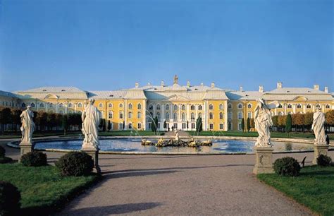 a large building with statues in front of it and a fountain on the other side