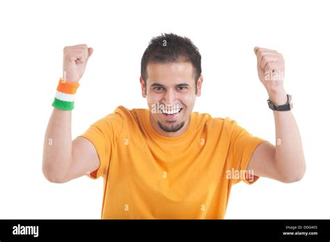 Portrait of an Indian young man with tricolor wristband in hand cheering up over white ...