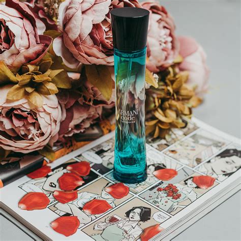 Blue Perfume Bottle On A Book Beside Flowers · Free Stock Photo