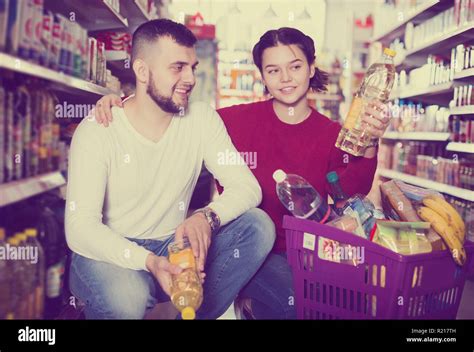 Smiling young family reading lable of olive oil bottle at supermarket Stock Photo - Alamy