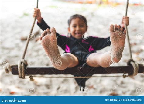 Child Feet with Sand while she Playing on a Swing at the Beach Near the ...