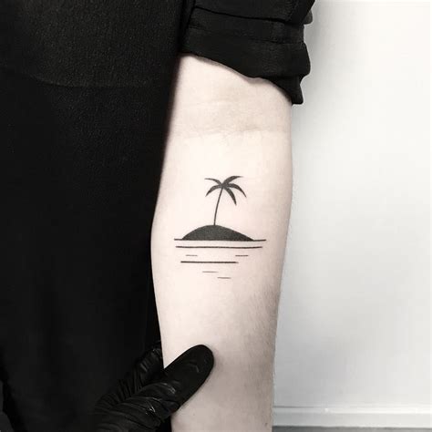 Small black island tattoo on the arm - Tattoogrid.net