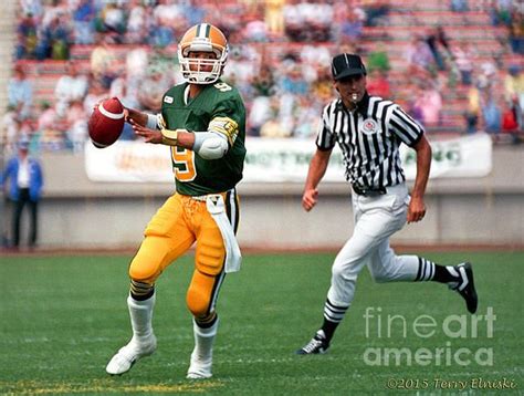 Action photograph of Edmonton Eskimos QB Damon Allen #9 rolling out and ...