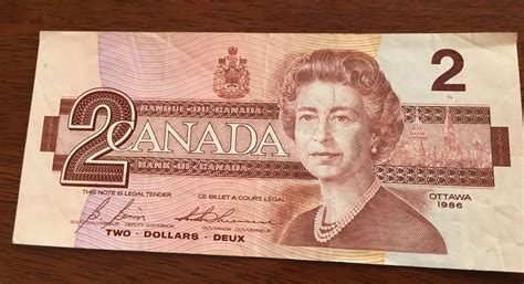 an old canadian two dollar bill with the image of queen elizabeth on it's face