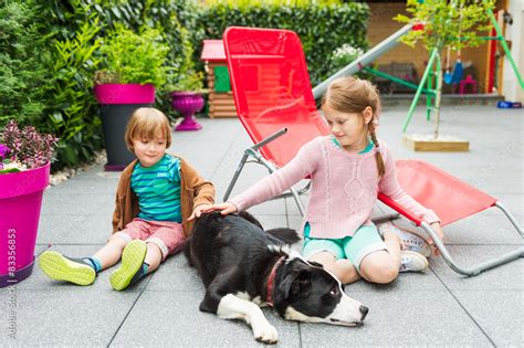 Cute kids playing with a dog on a backyard Stock Photo | Adobe Stock