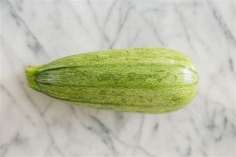 a green zucchini sitting on top of a marble counter