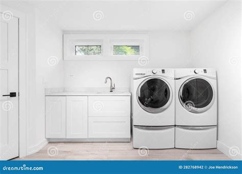 A Laundry Room with White Cabinets and Appliances. Stock Photo - Image ...