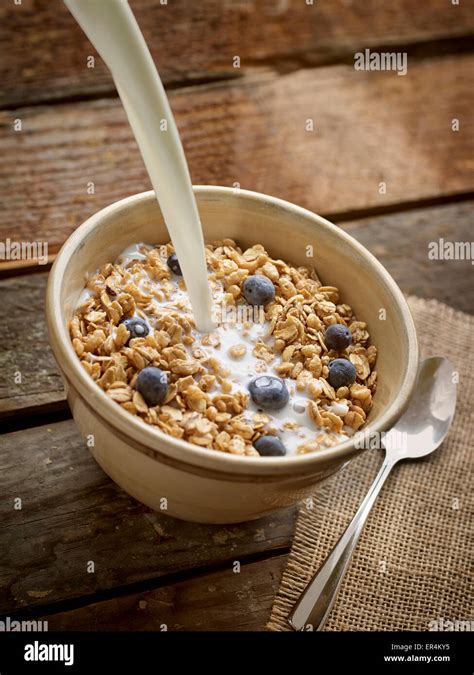 Bowl Of Granola Cereal With Milk Pouring Stock Photo - Alamy