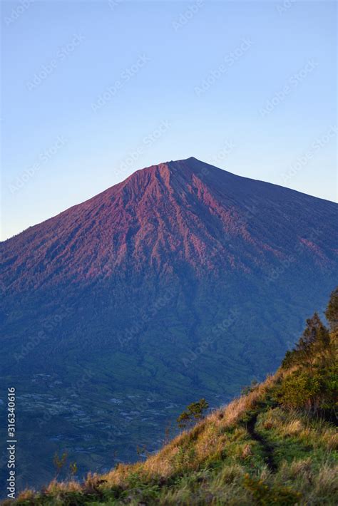 (Selective focus) Stunning view of the Mount Rinjani illuminated by a beautiful sunrise. Mount ...