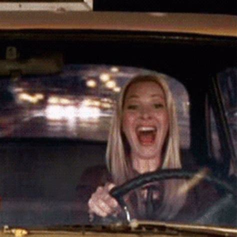 a woman is laughing while driving in a car with her mouth open and ...