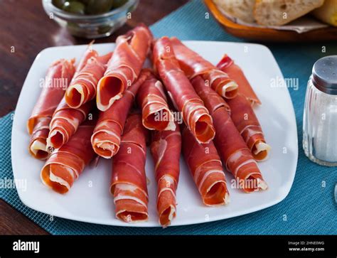 Dry-cured ham slices on white platter Stock Photo - Alamy