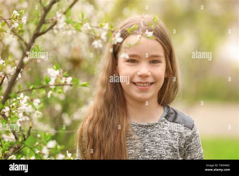 Cute little girl walking in spring park Stock Photo - Alamy